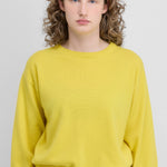 Front view of sunny jewel sweater on model wearing grey trousers, against a white background.