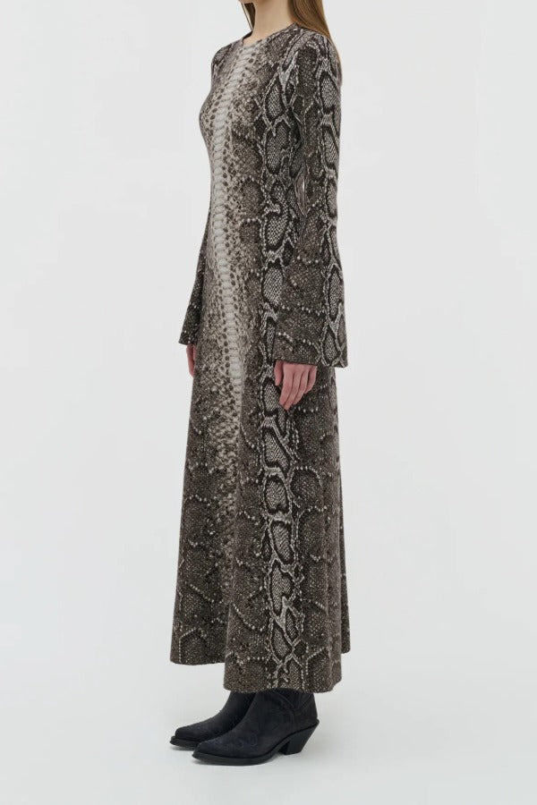 Side view of greyscale aalia dress on model wearing boots, against a white background.