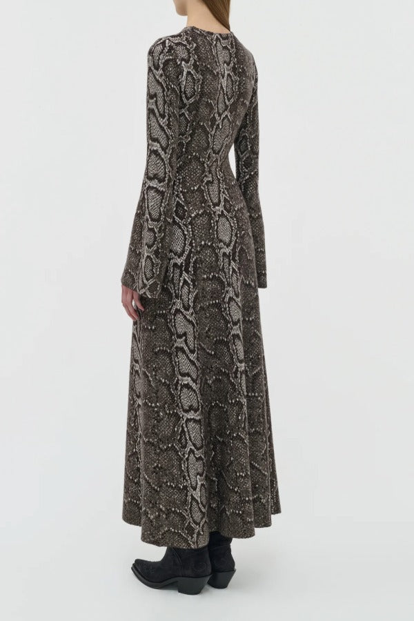 Back view of greyscale aalia dress on model wearing boots, against a white background.