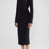 Front view of black geo petra skirt on model wearing black top and flats, against a white background.