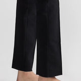 Bottom of pant closeup view of black tuxedo julep pant on model wearing flats, against a white background.