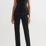 Front view of black combo windowpane inna top on model wearing black pants and flats, against a white background.