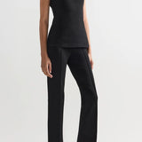 Alternate front slanted view of black combo windowpane inna top on model wearing black pants and flats, against a white background.