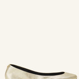 Left side view of gold ballerina flats on white background, with no model shown.