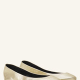 Pair view of gold ballerina flats on white background, with no model shown.