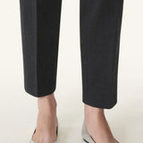 Front and side view of silver ballerina flats on model wearing black pants, against a white background.