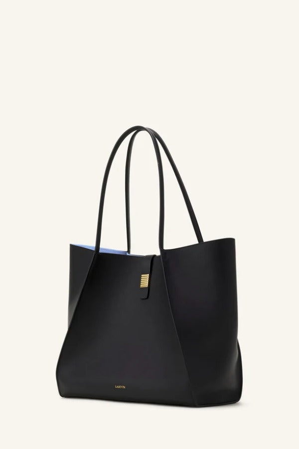 Side view of black tote bag on white background, with no model shown.