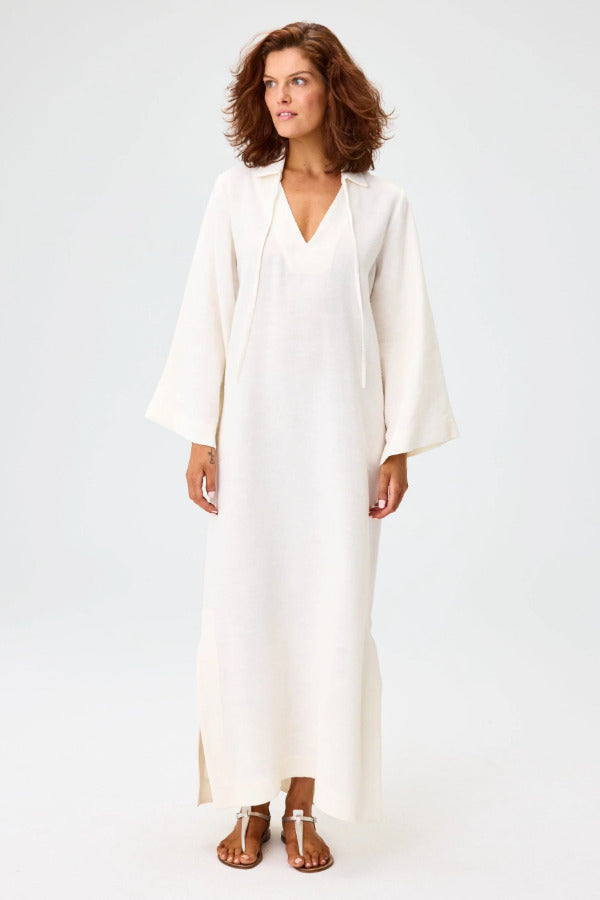 Front view of white tunic caftan on brown-haired model wearing silver sandals, against a white background.