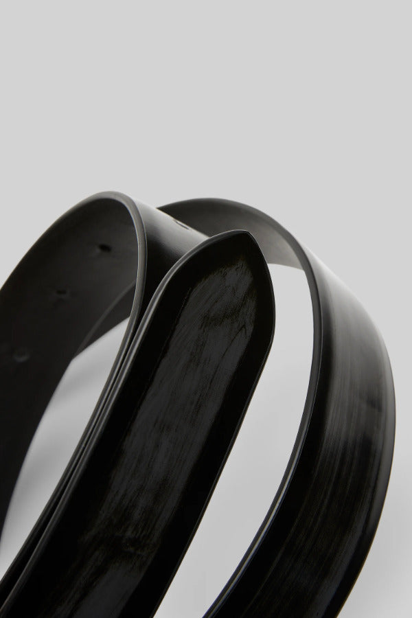 Closeup of black marsell men's contorno belt on white background, with no model shown.
