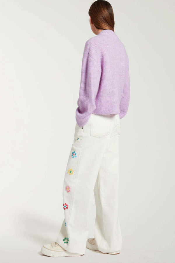 Back view of white straight leg jean on model wearing purple sweater and white sneakers, against a white background.