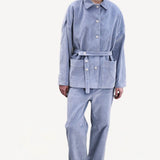 Front view of blue ice esra marine pants on model wearing blue ice jacket and boots, against a white background