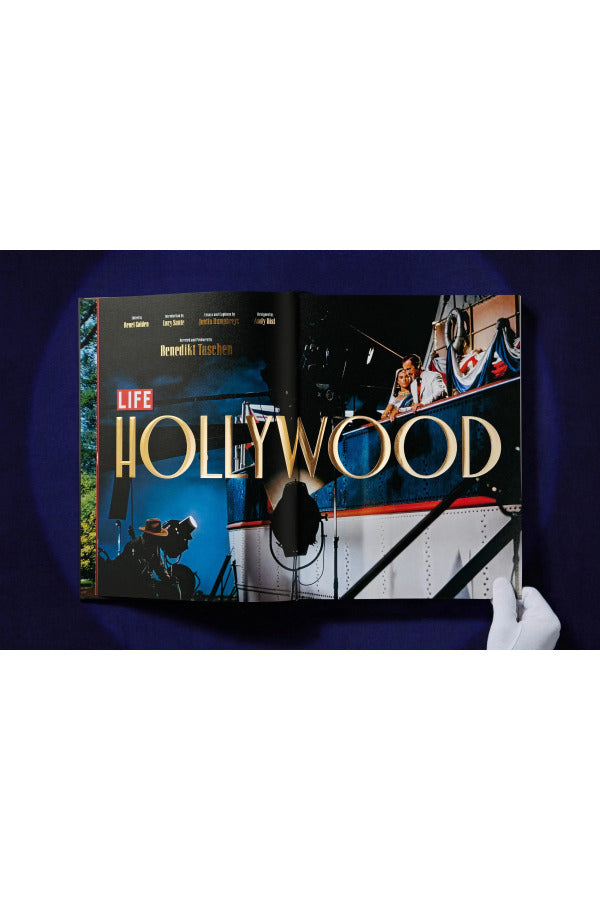 Open book view of taschen life hollywood book on blue background.