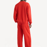 Back view of sanguinello sweatpant on dark-haired model wearing sanguinello sweatshirt, against white background.
