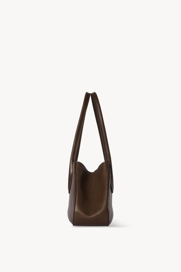 Side view of deep brown alger shoulder bag on white background, with no model shown.
