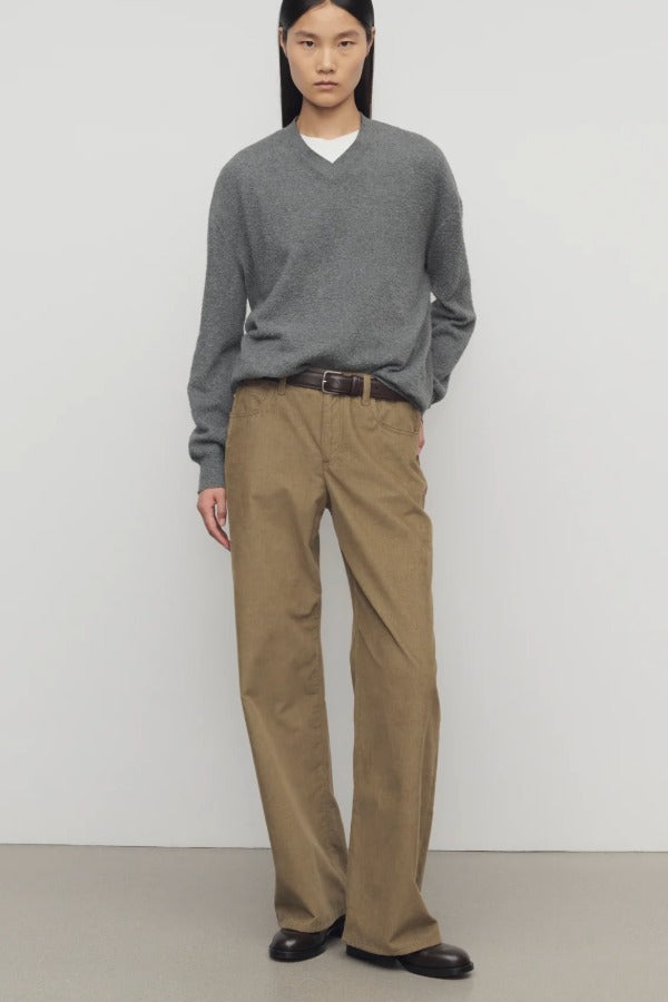 Front view of beige eglitta pant on model wearing grey sweater and boots, against a white background.