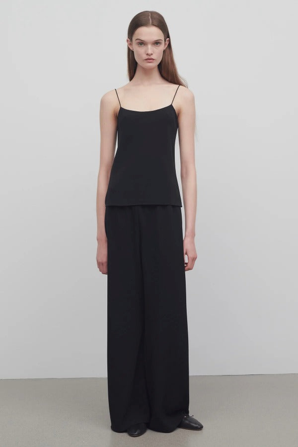 Front view of black gala pant on model wearing black top, against a white background.