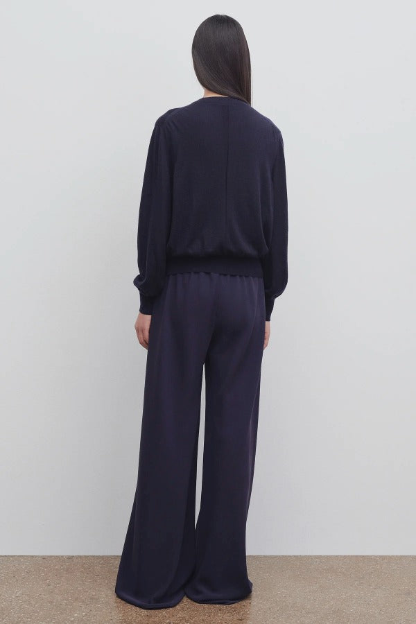 Back view of navy gala pant on model wearing black top, against a white background.