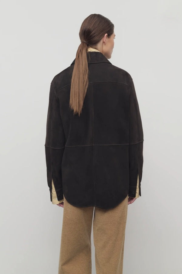 Back view of dark brown gwena jacket on model wearing khaki pants, against a white background.