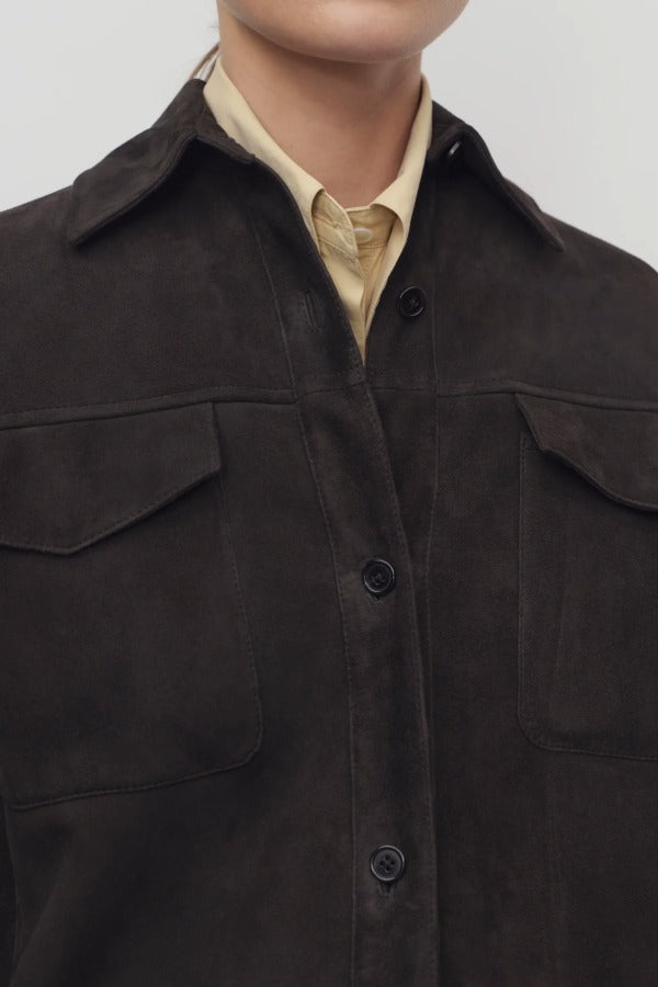 Front closeup view of dark brown gwena jacket on model wearing yellow shirt, against a white background.