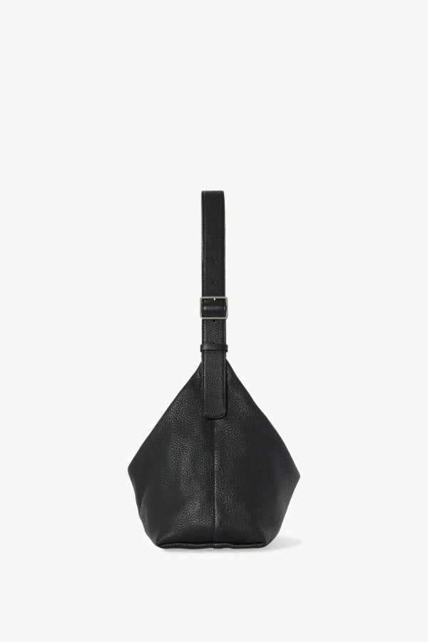 Side view of black isa shoulder bag on white background, with no model shown.