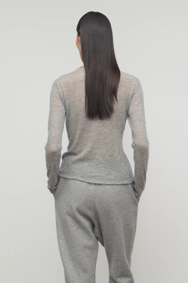 Back view of grey melange iverness top on model wearing grey sweatpants, against a white background.