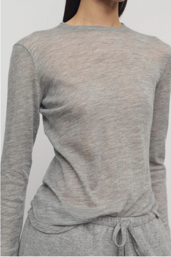 Front closeup view of grey melange iverness top on model wearing grey sweatpants, against a white background.