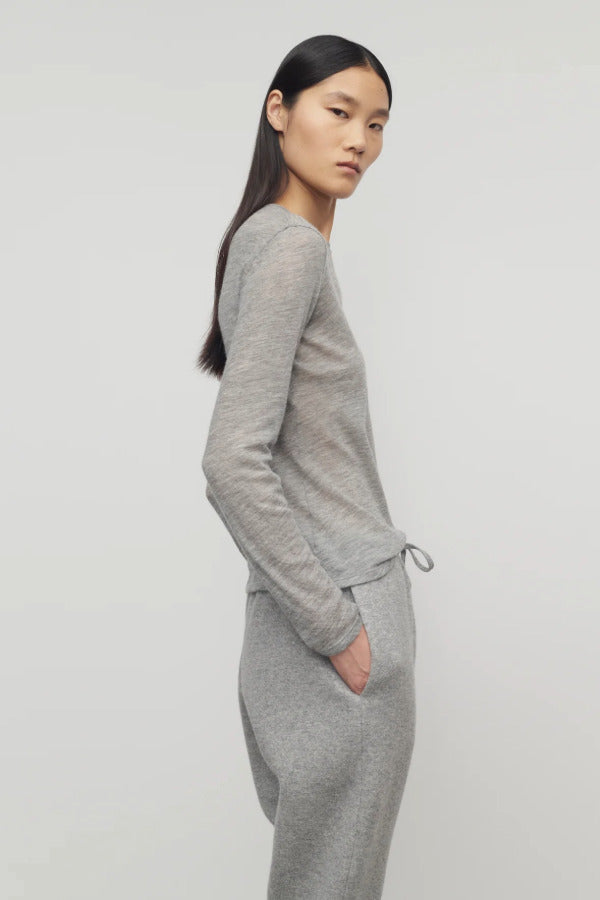 Side view of grey melange iverness top on model wearing grey sweatpants, against a white background.
