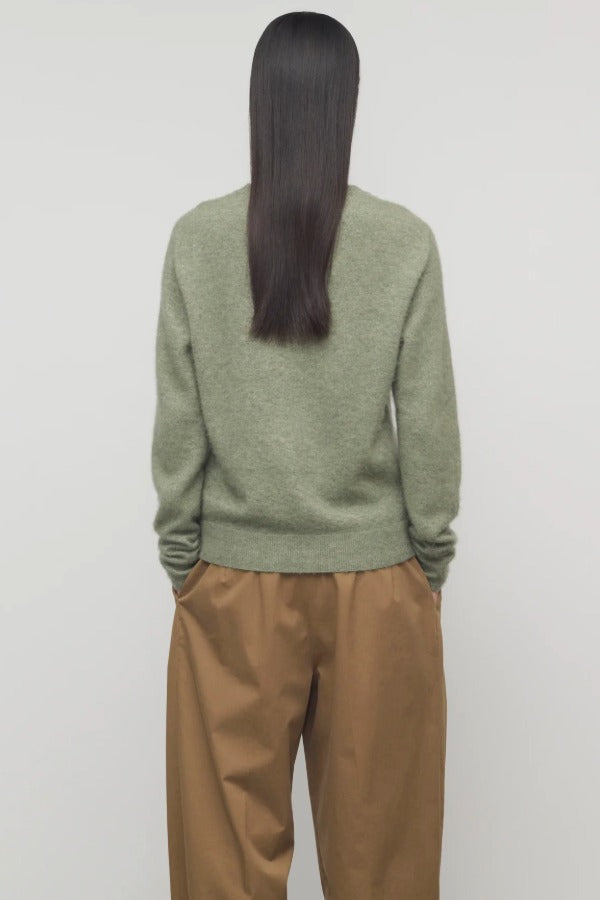 Back view of sage lorynna top on model wearing camel trousers, against a white background.