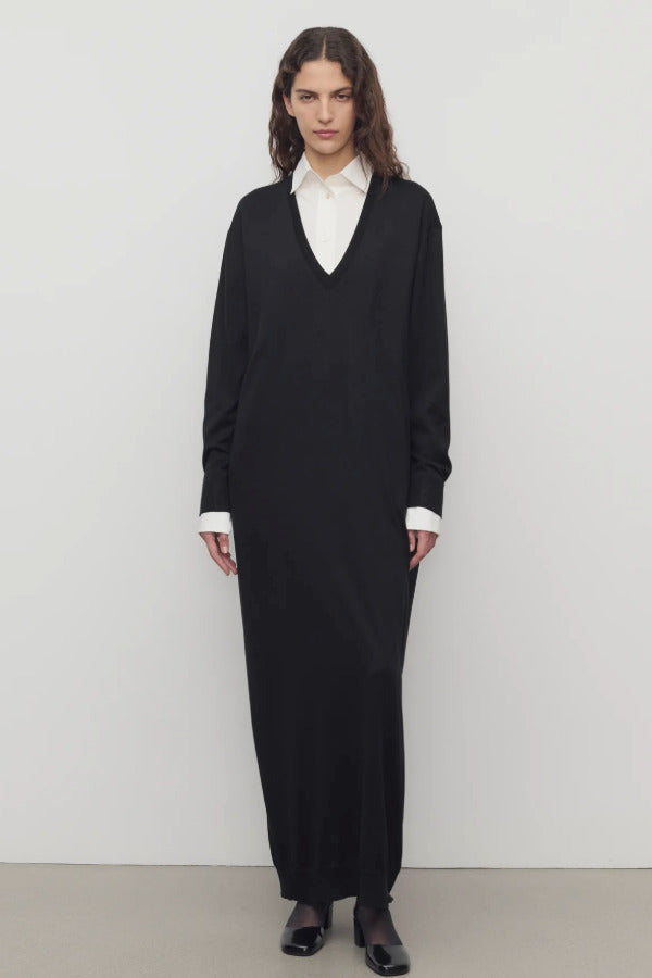 Front view of black luza dress on model wearing white collar shirt and black wedges, against a white background.