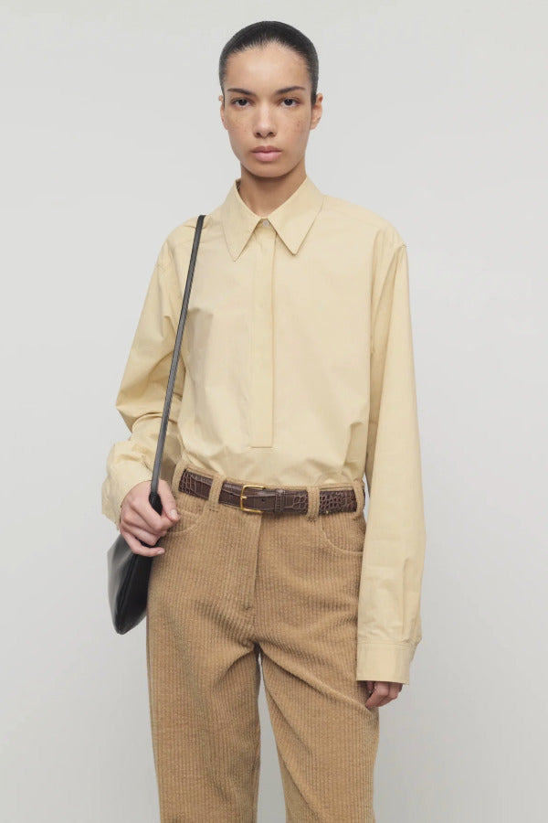 Front view of sand margan shirt on model wearing orange corduroys and brown belt, against a white background.