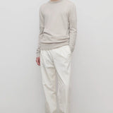 Front view of white belamy pant on model wearing beige top and sneakers, against a white background.