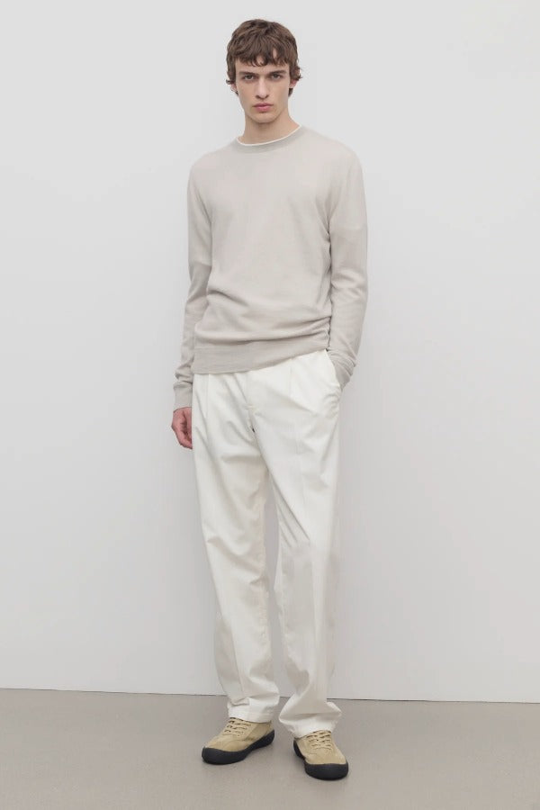Front view of white belamy pant on model wearing beige top and sneakers, against a white background.