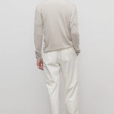 Back view of white belamy pant on model wearing beige top and sneakers, against a white background.