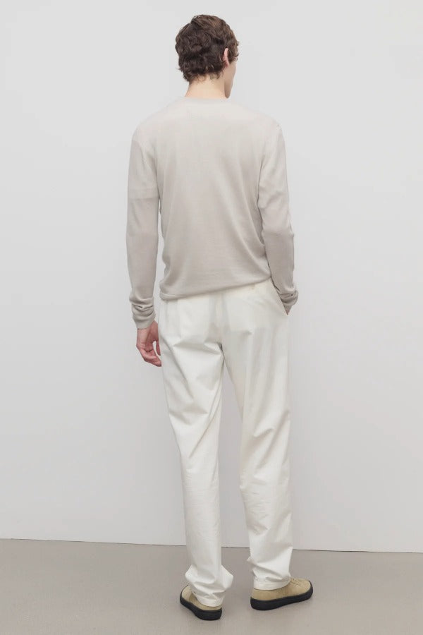 Back view of white belamy pant on model wearing beige top and sneakers, against a white background.