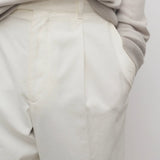 Front closeup view of white belamy pant on model wearing beige top, against a white background.
