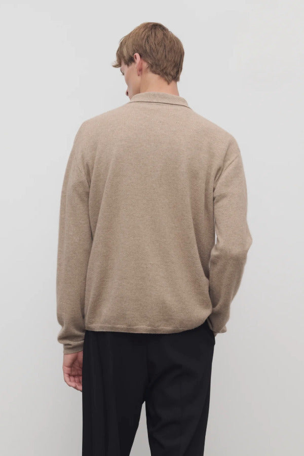 Back view of taupe men's franz sweater on model wearing black trousers, against a white background.