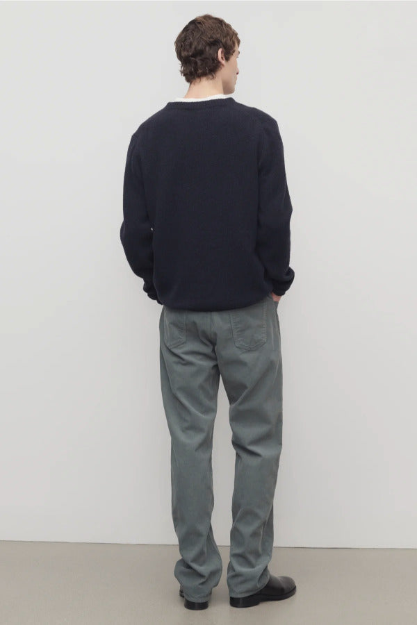 Back view of grey men's fred pants on model wearing black sweater and boots, against a white background.