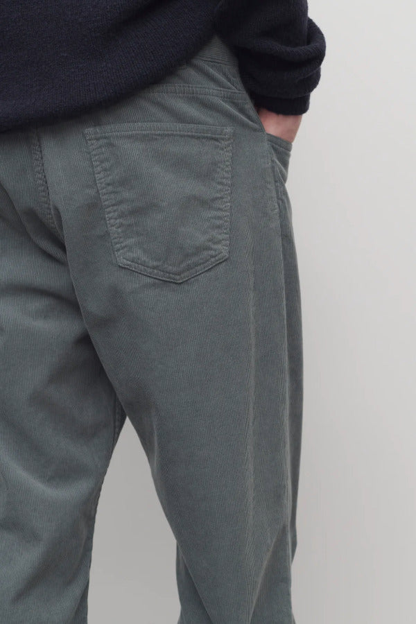 Back closesup view of grey men's fred pants on model wearing black sweater, against white background.