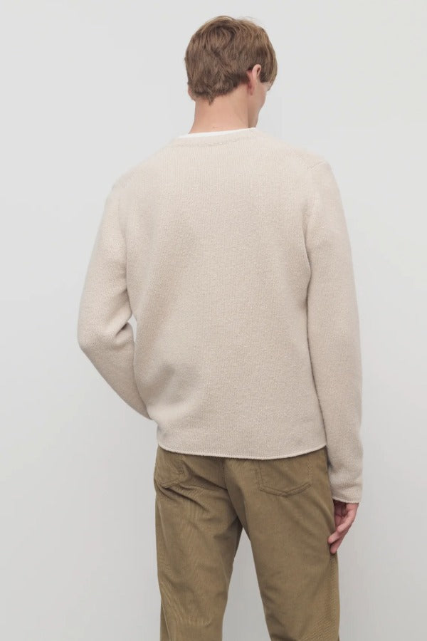 Back view of ecru nikola sweater on model wearing khakis, against a white background.
