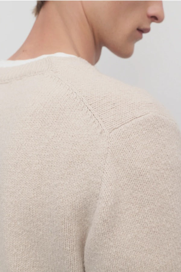 Back closeup view of ecru nikola sweater on model, against a white background.