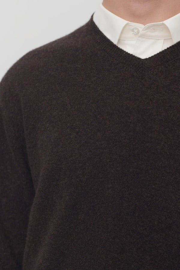 Front closeup of brown melange rod sweater on model wearing white shirt, against a white background.