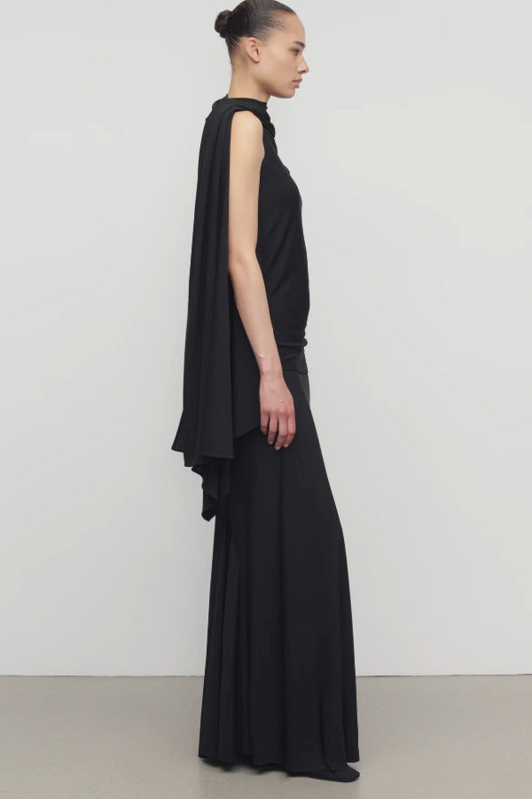 Side view of black mirla skirt on model wearing black top, against a white background.