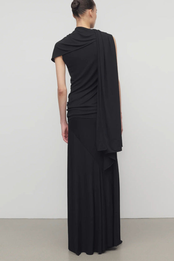 Back view of black mirla skirt on model wearing a black top, against a white background.