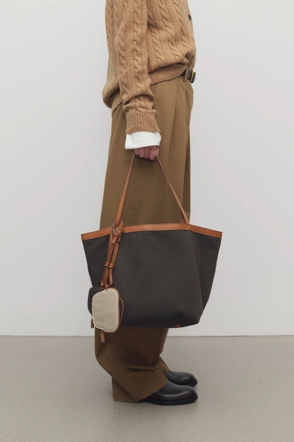 Front view of brown park tote three canvas on model wearing camel pants, sweater and boots, against a white background.