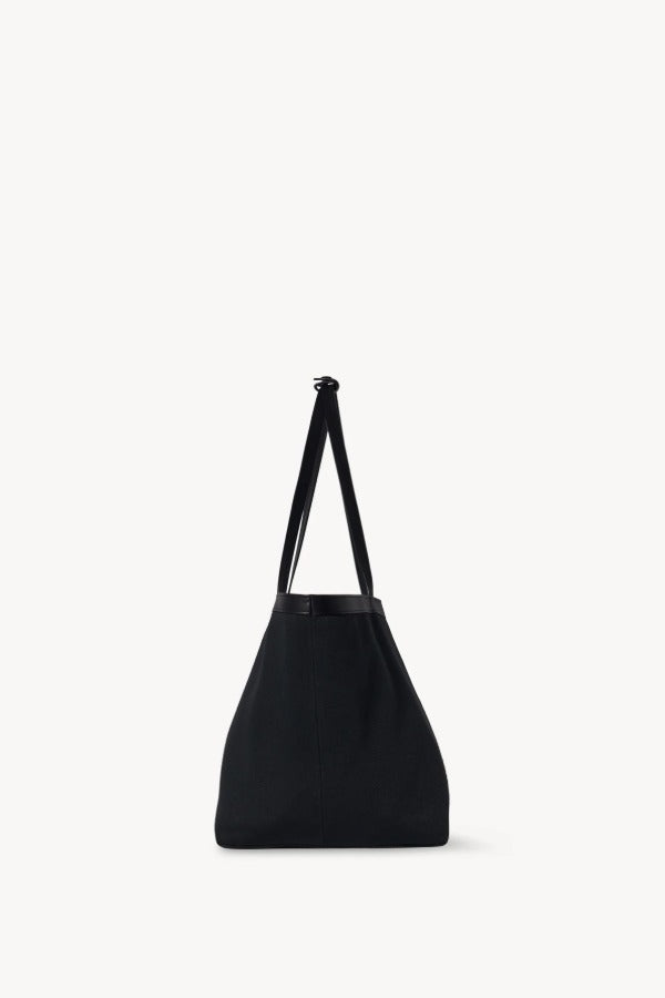 Side view of black park tote three canvas on white background, with no model showm.