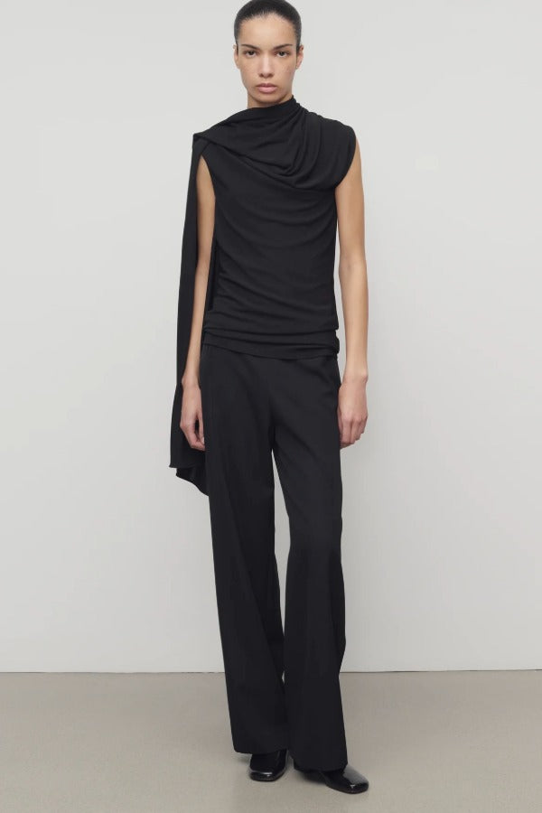 Front view of black roger pant on model wearing black top and heels, against a white background.