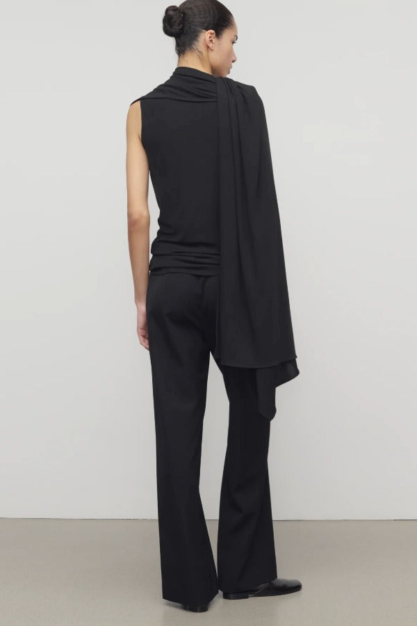 Back view of black roger pant on model wearing black top and heels, against a white background.