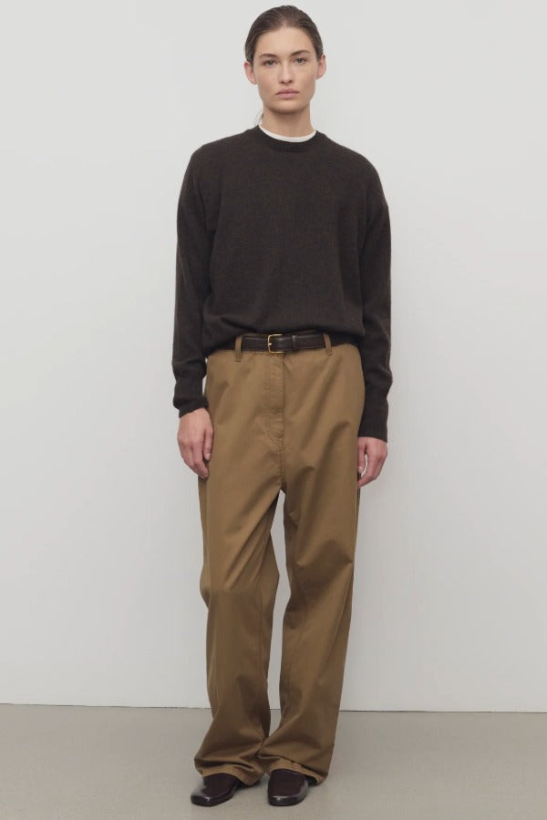 Front view of dark sand sharka pant on model wearing black shirt, against a white background