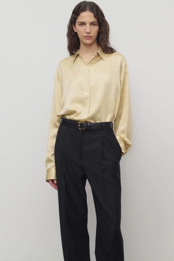 Front view of sand takara shirt on model wearing black pants and black belt, against a white background.