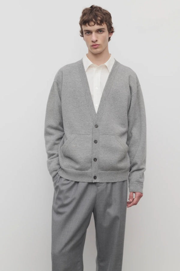 Front view of grey melange vonn cardigan on model wearing grey trousers and a white shirt, against a white background.